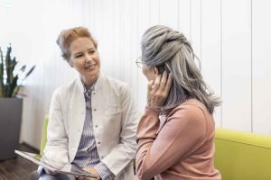 Older man speaking with a hearing care professional during a hearing aid consultation